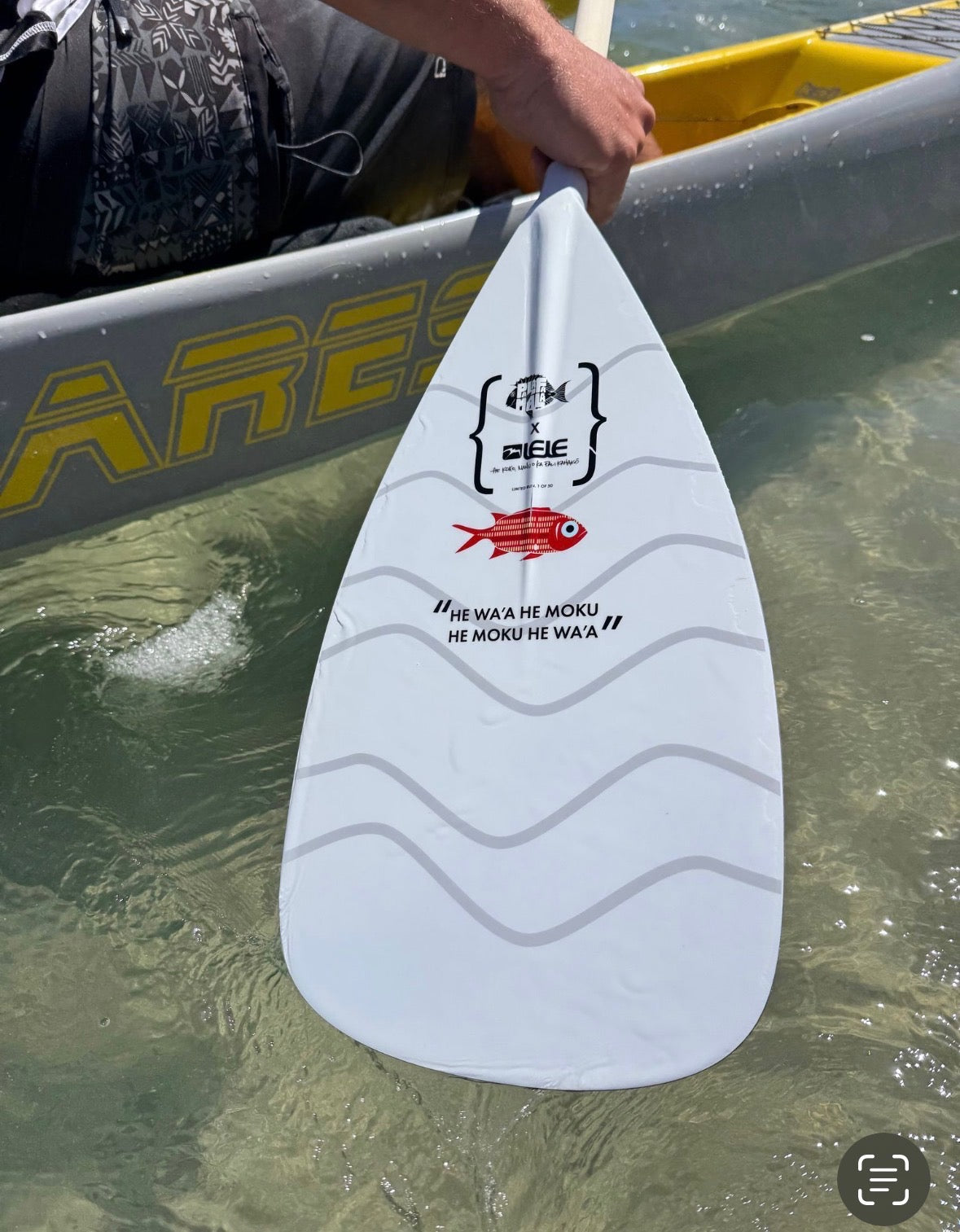 small red fish on white paddle with water lines